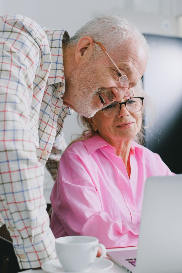 team-02 Elderly couple enjoying time together while using a laptop at home.